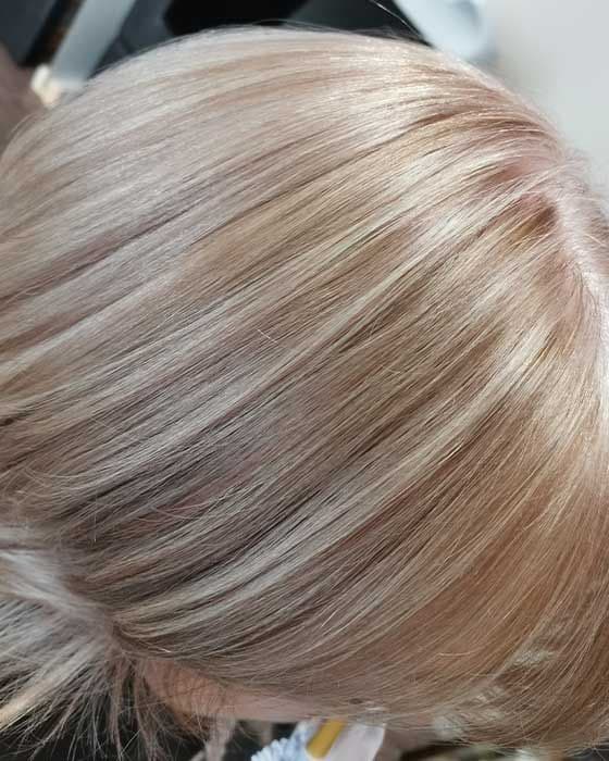 Nahaufnahme eines Hinterkopfs mit feinen Strähnen in mehreren Blondtönen.