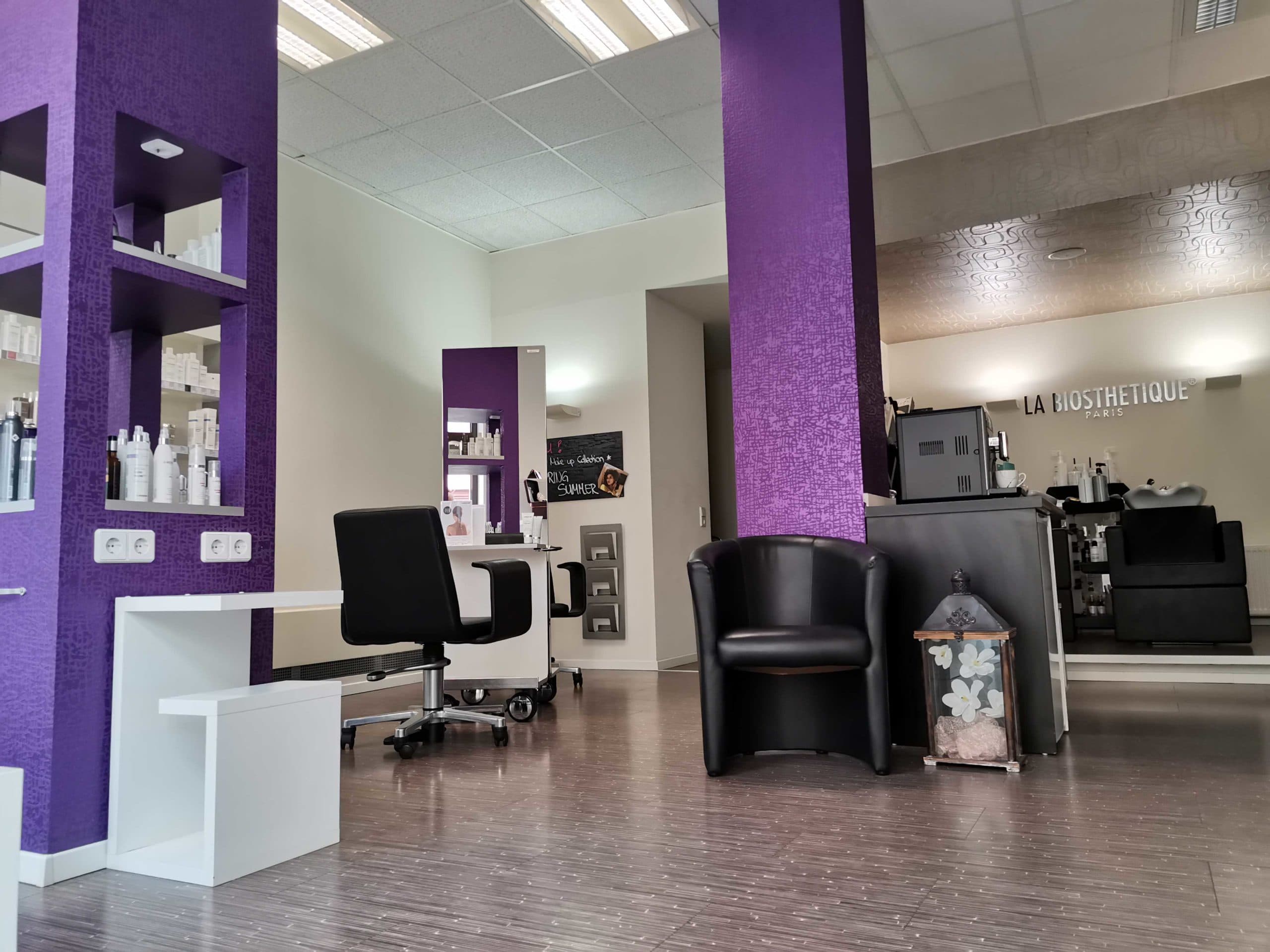 Blick in den Salon: Produktregale, ein Sessel zum Warten, Frisierplätze und im Hintergrund die Waschplätze.